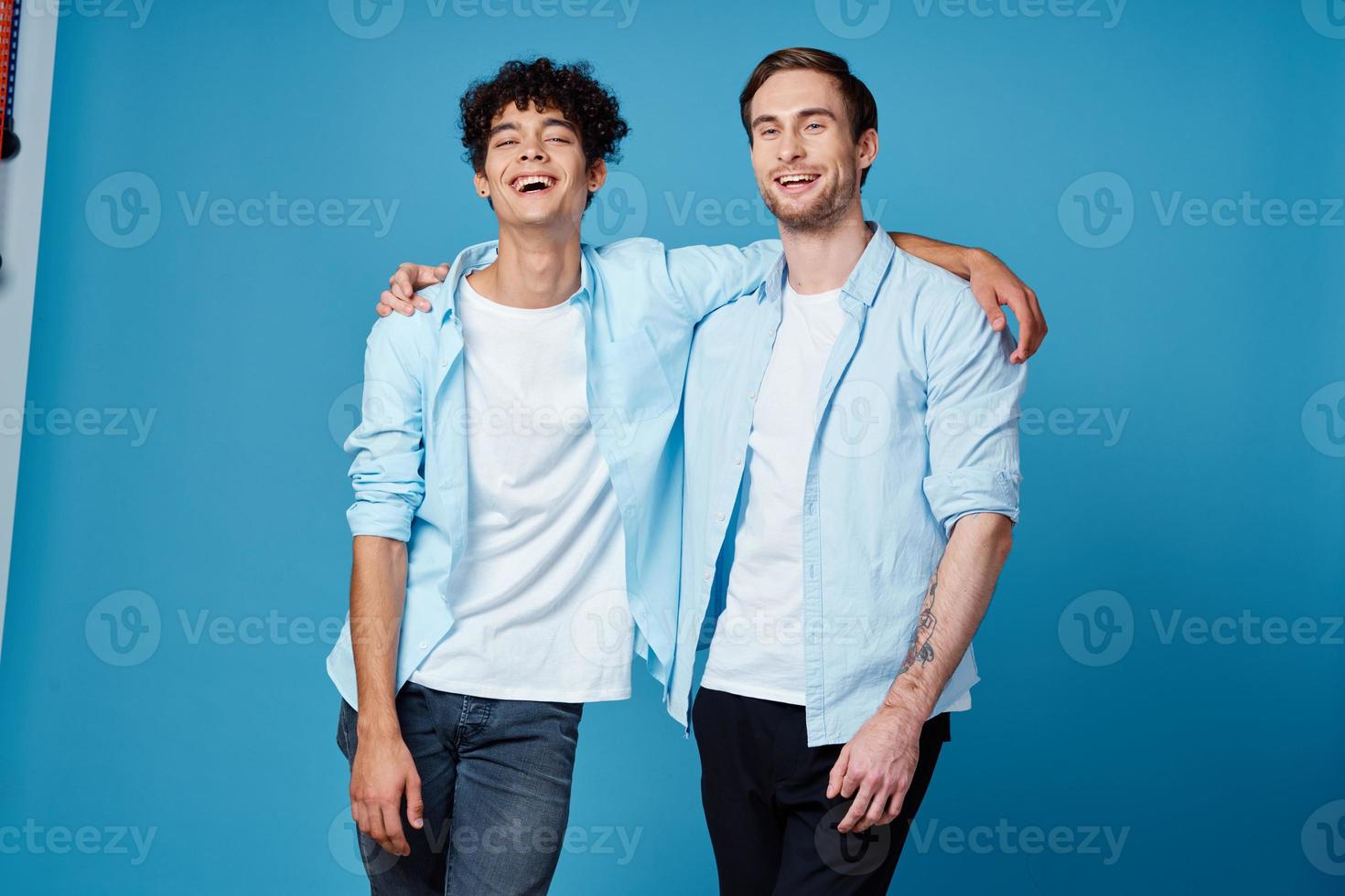 best friends hugging on blue background in matching t-shirts cropped view photo