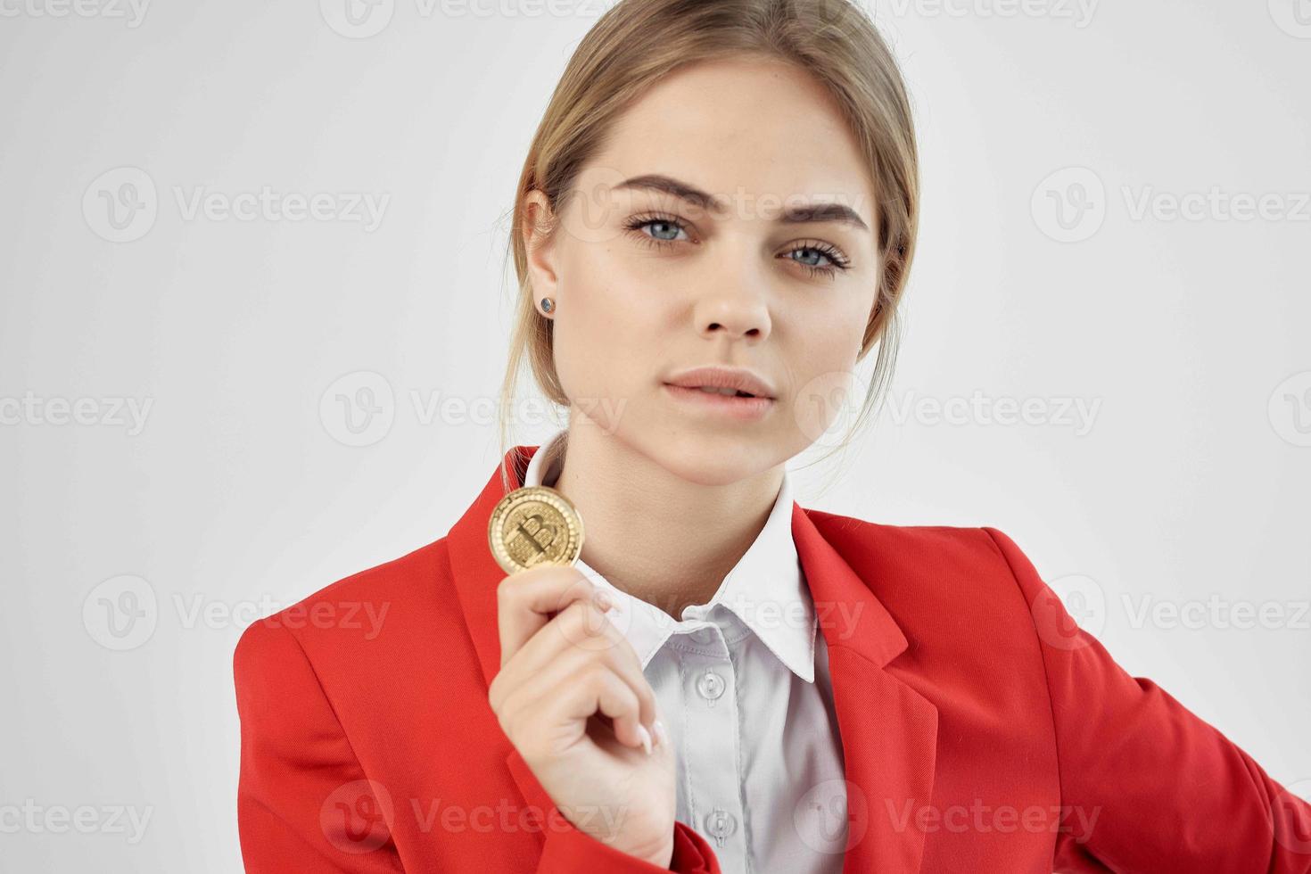 mujer de negocios en un rojo chaqueta oro moneda bitcoin ligero antecedentes foto