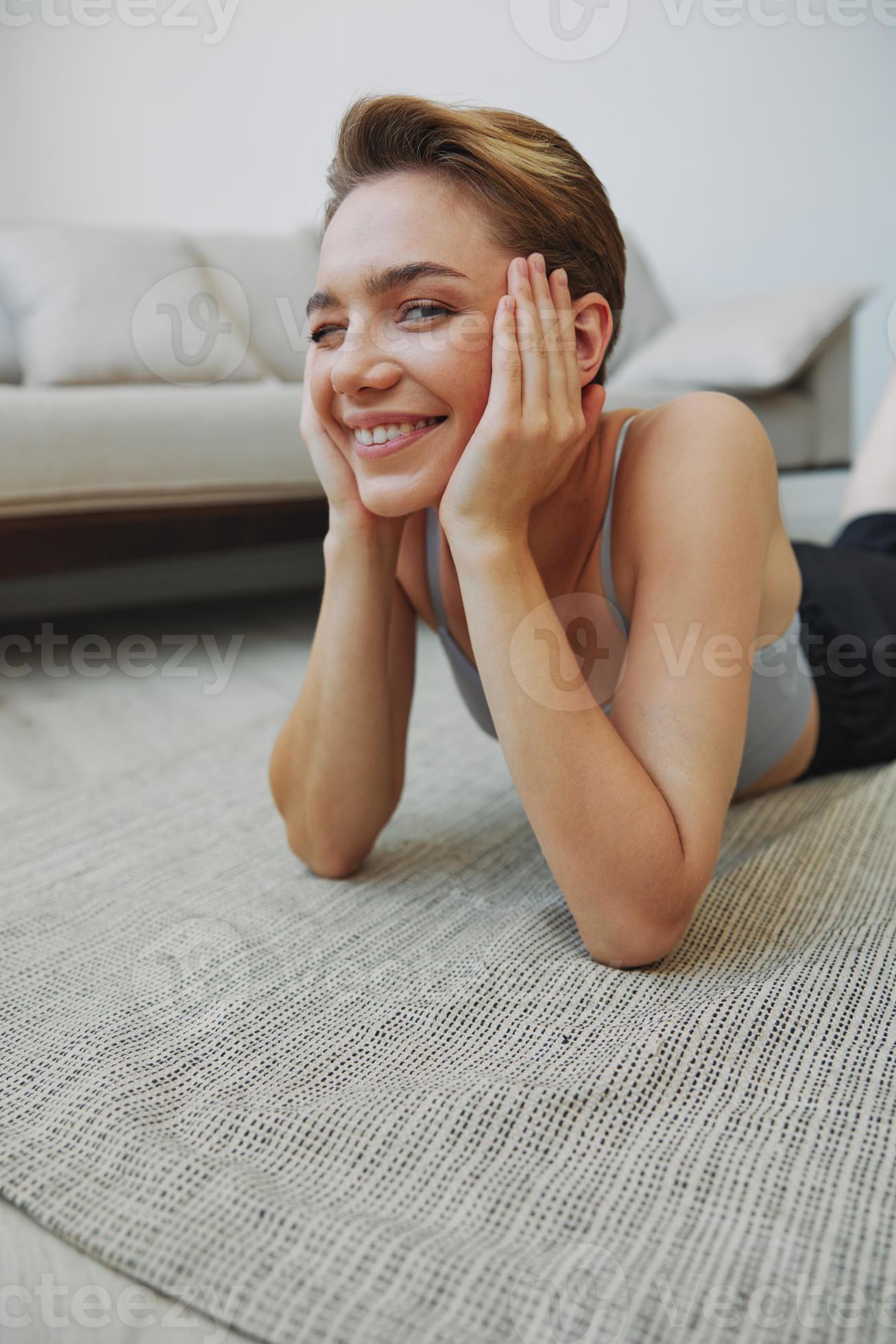 Teenage girl lying on the floor at home smiling in home clothes with a