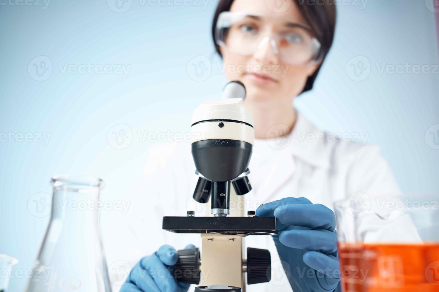 woman scientist looking through a microscope laboratory research diagnostics photo