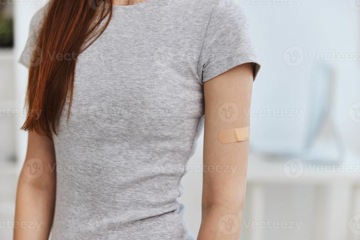 woman t-shirt with adhesive plaster on shoulder immunity health covid passport photo