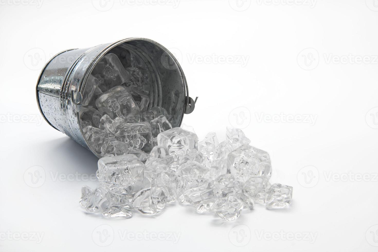 Ice bucket on its side with spilt ice isolated on a white background. photo