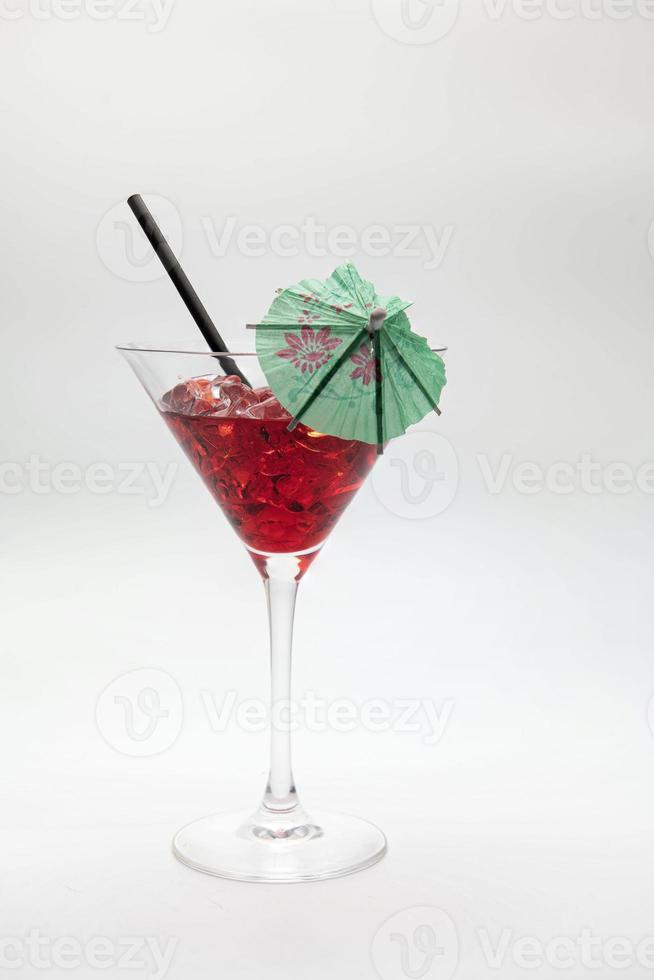 Red cocktail drink with green umbrella isolated on a white background. photo