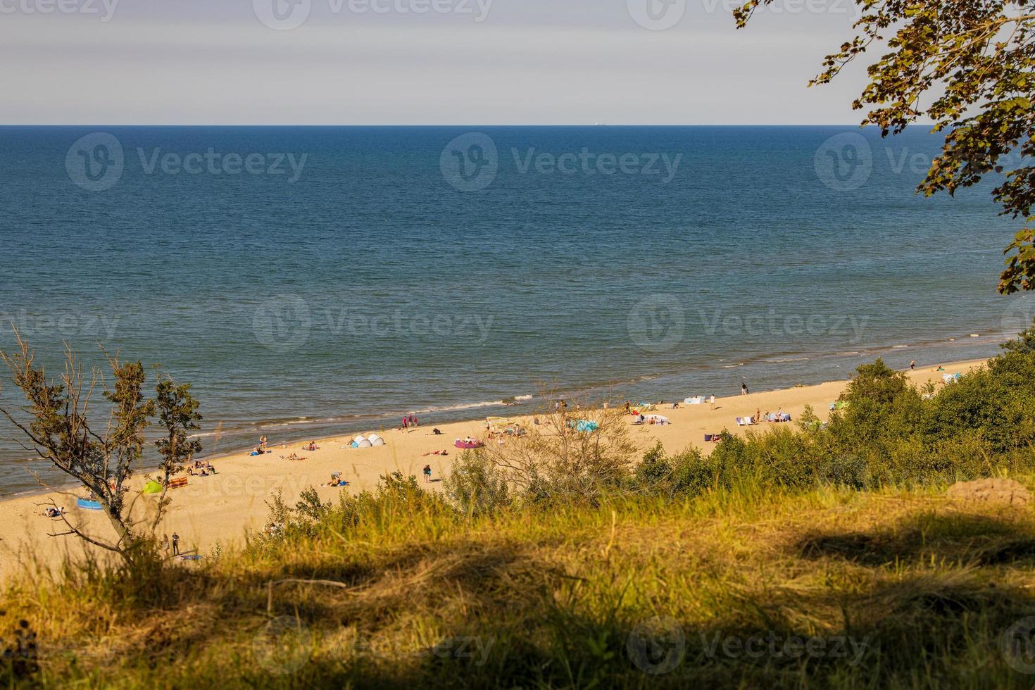 view from the escarpment to the beach on the Baltic Sea on a summer day with people photo