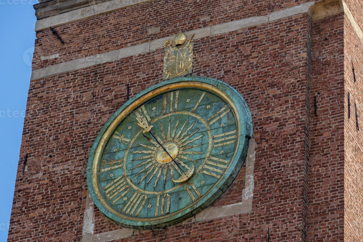 antique clock on a brick tower in Krakow, Poland photo