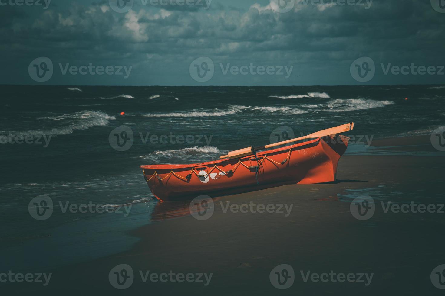an orange lifeguard boat on a beach in leba in Poland on a warm  day photo