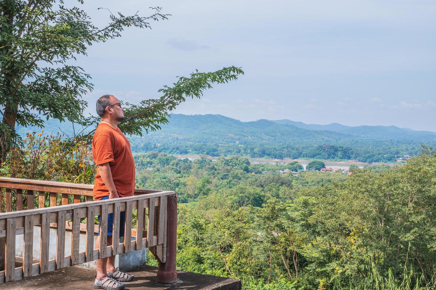 Asia fat guy with landscape view on phu chang noi chiang khan district loei city thailand.Chiang Khan is an old town and a very popular destination for Thai tourists photo