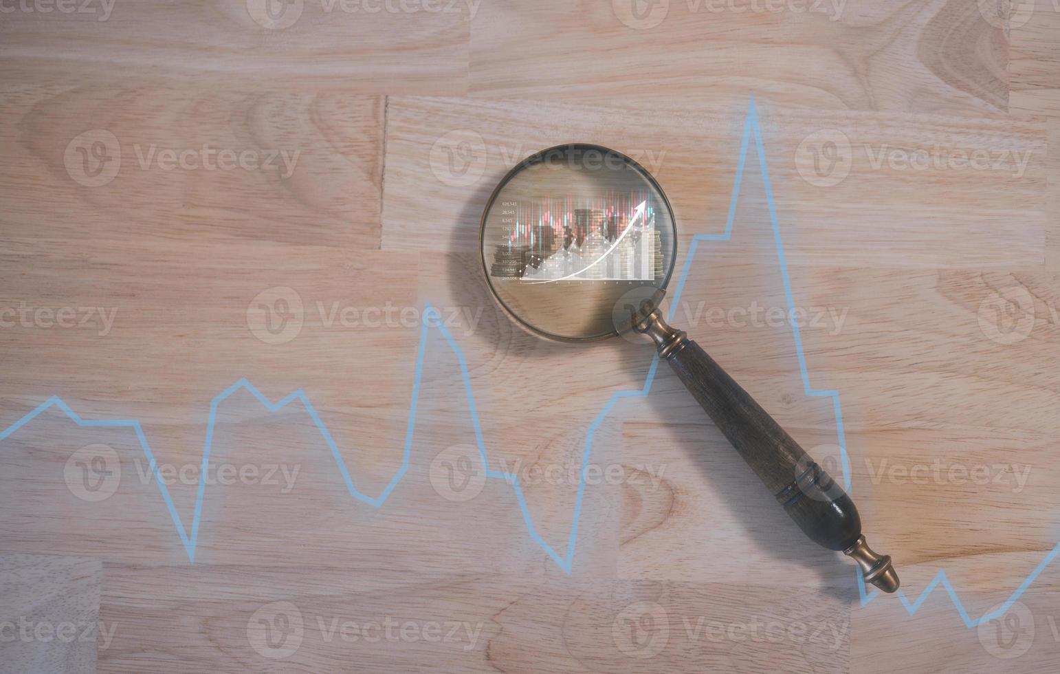 investment strategy concept, magnifying glass background with trading graph blurred coins searching for best option to investment in stock market or mutual funds, stock market, trading graph, photo