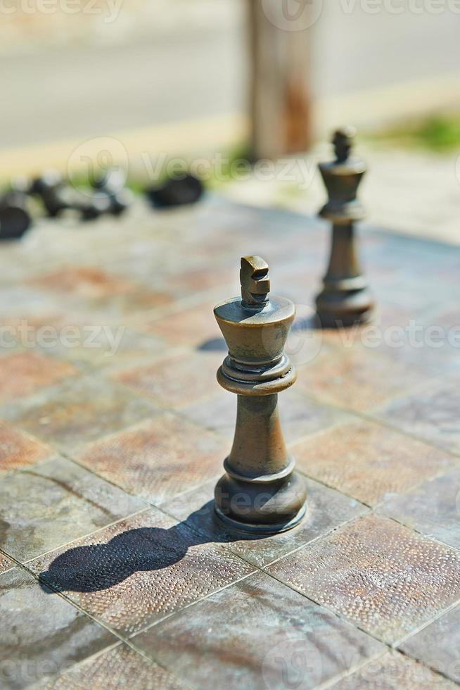 Metal chess pieces on a metal chessboard photo