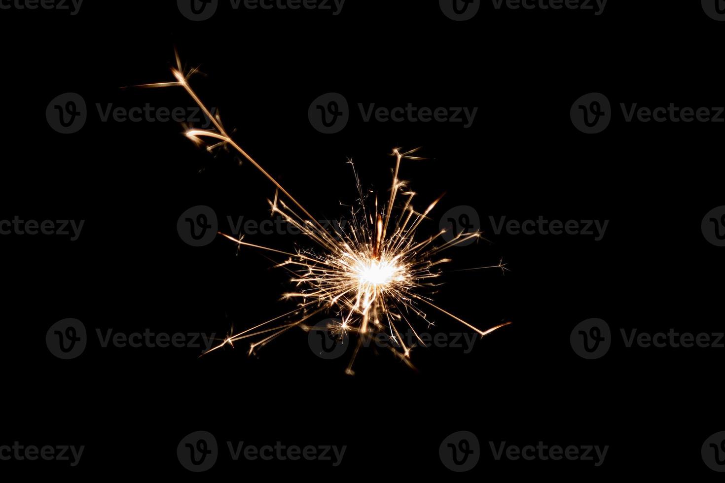 Burning sparkler isolated on black background. Fireworks theme. Light effect and texture. photo