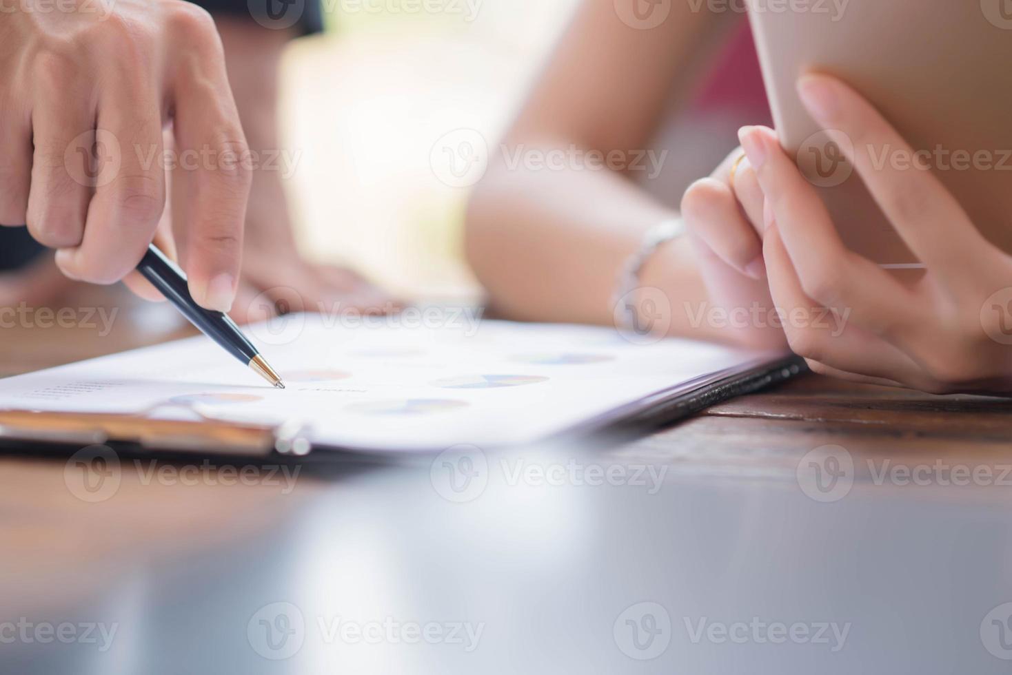Businessman checking graph with a laptop, phone and alarm clock on the table when the morning light. photo