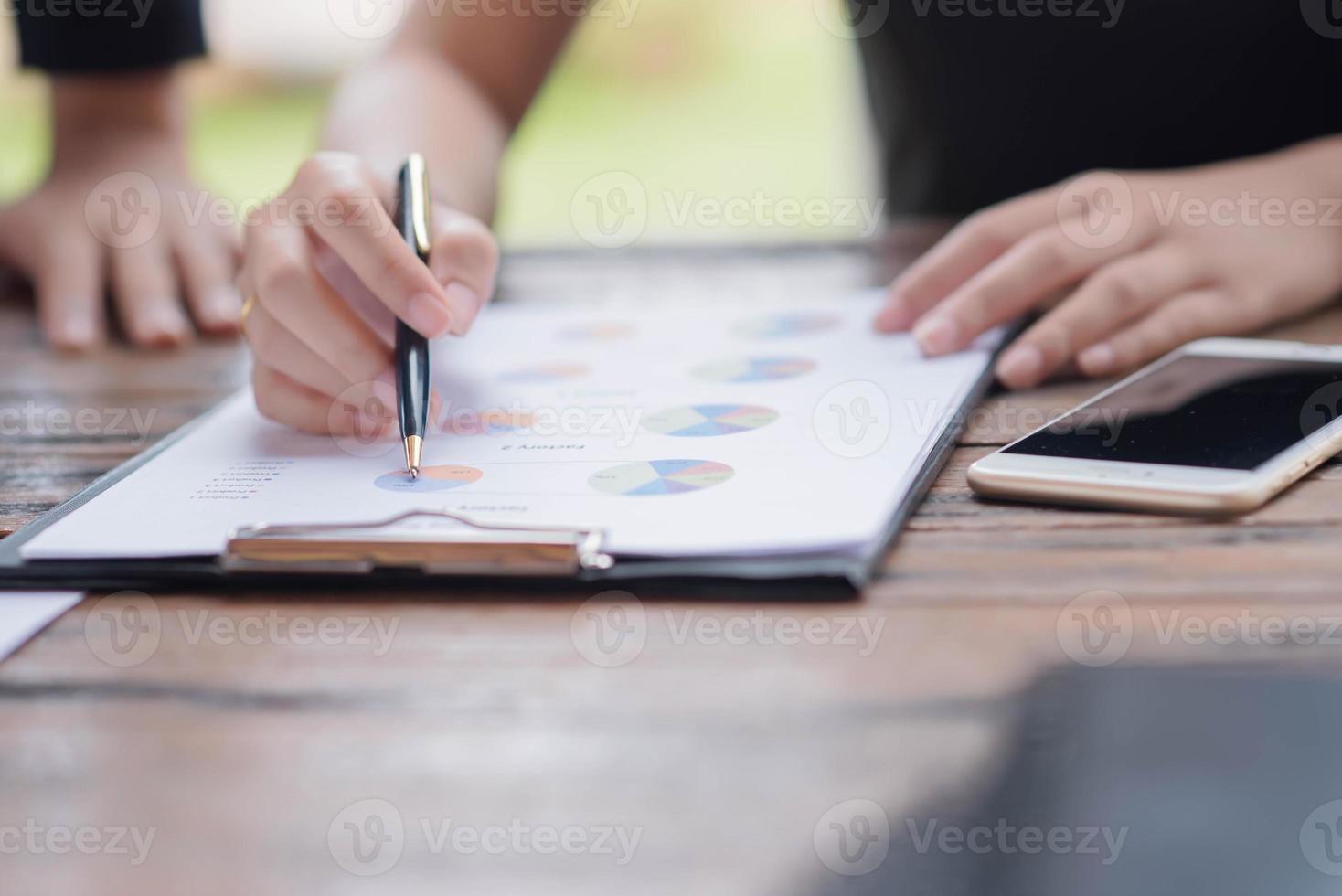 Businessman checking graph with a laptop, phone and alarm clock on the table when the morning light. photo
