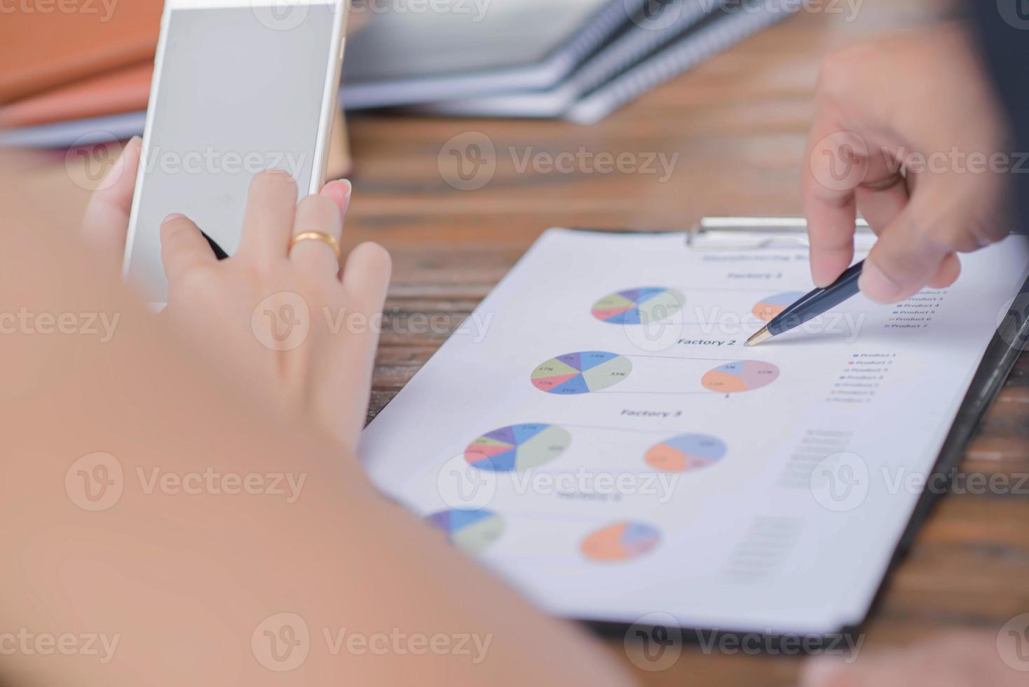 Businessman checking graph with a laptop, phone and alarm clock on the table when the morning light. photo