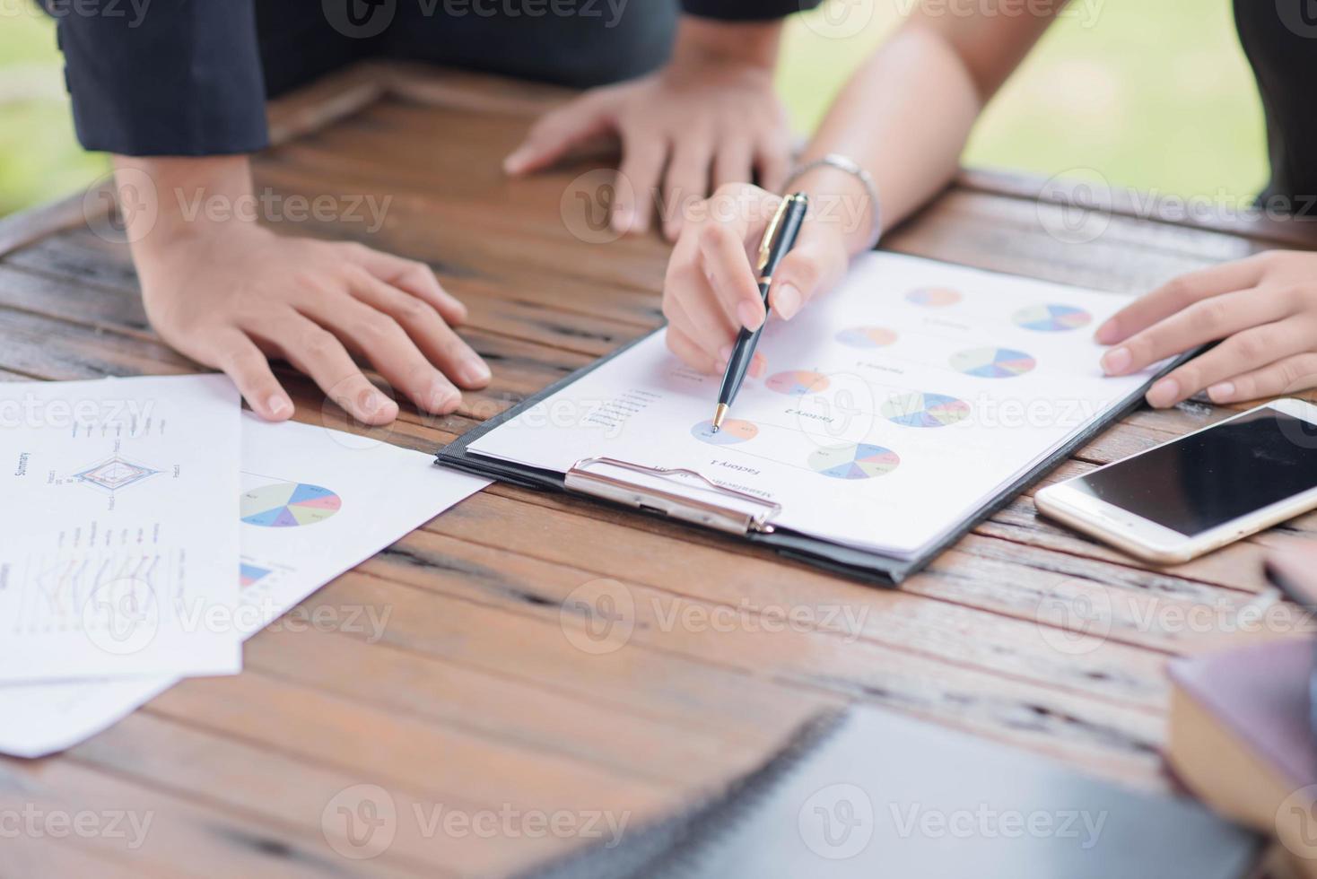 Businessman checking graph with a laptop, phone and alarm clock on the table when the morning light. photo