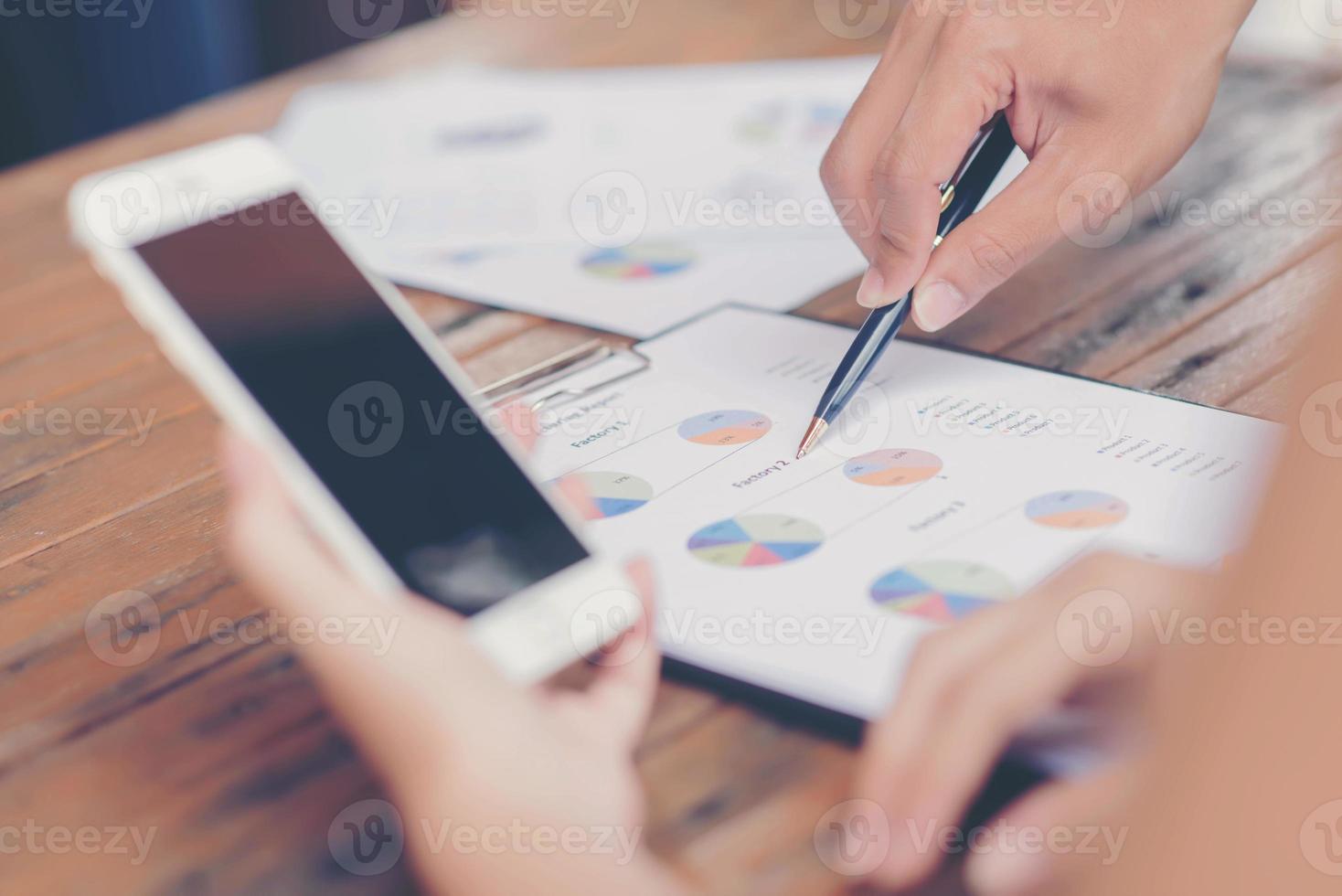 Businessman checking graph with a laptop, phone and alarm clock on the table when the morning light. photo