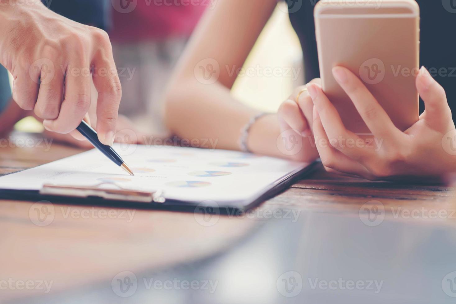 Businessman checking graph with a laptop, phone and alarm clock on the table when the morning light. photo
