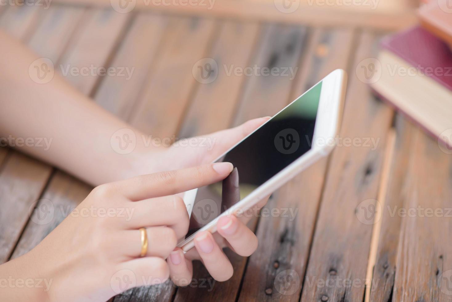 Young businesswoman hard at work at her desk writing notes on a pad from her laptop computer with analytical charts and graphs in front of her, high angle view photo