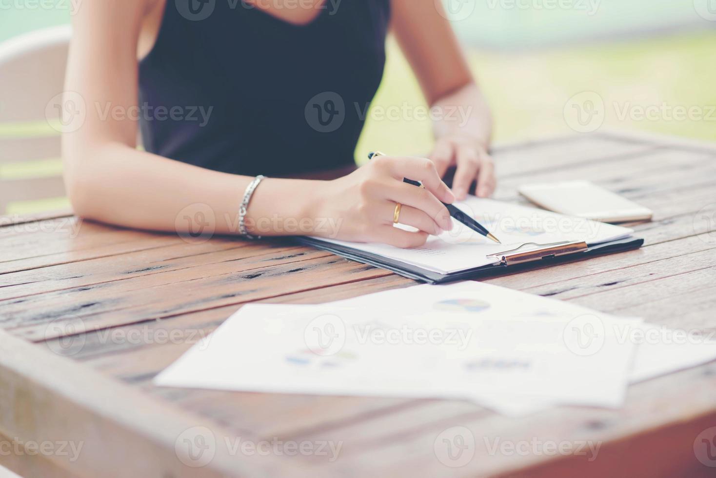 Businessman checking graph with a laptop, phone and alarm clock on the table when the morning light. photo
