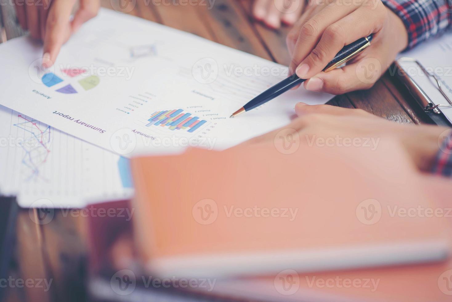 Businessman checking graph with a laptop, phone and alarm clock on the table when the morning light. photo