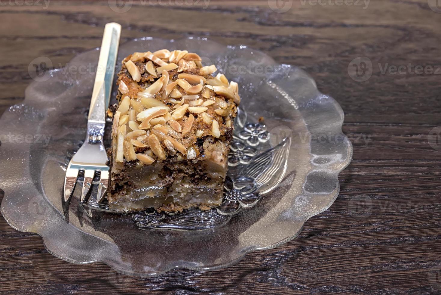 Delicate piece of chocolate cake, torte with nuts on a plate with a fork. photo