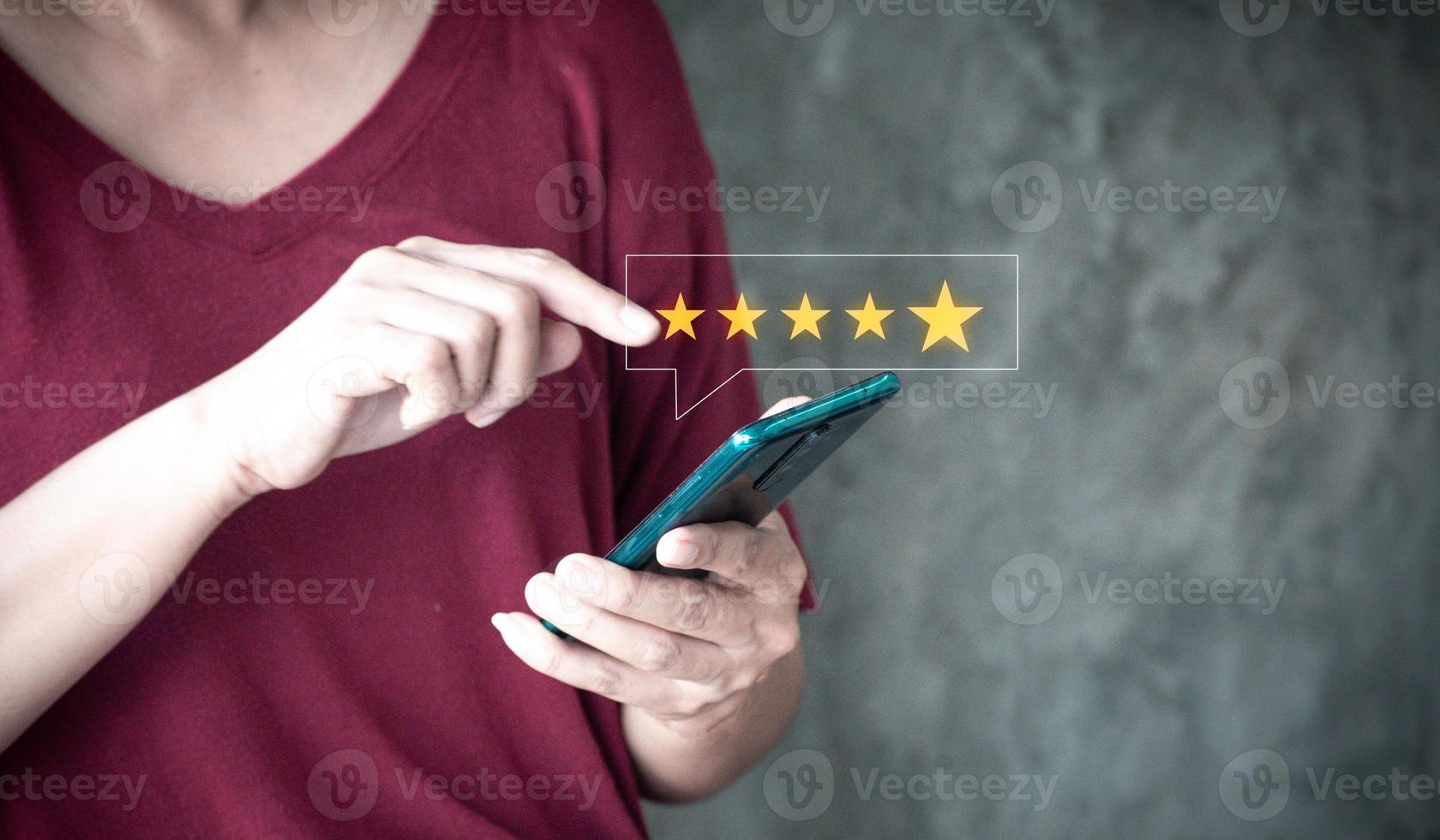 close up woMan hand using smartphone with popup five star icon for feedback review satisfaction service, Customer service experience and business satisfaction survey. photo