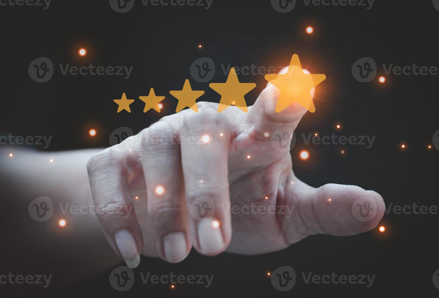 Hand pointing at five star rating on black background. Customer review concept. Customer service evaluation concept. rating very impressed. photo