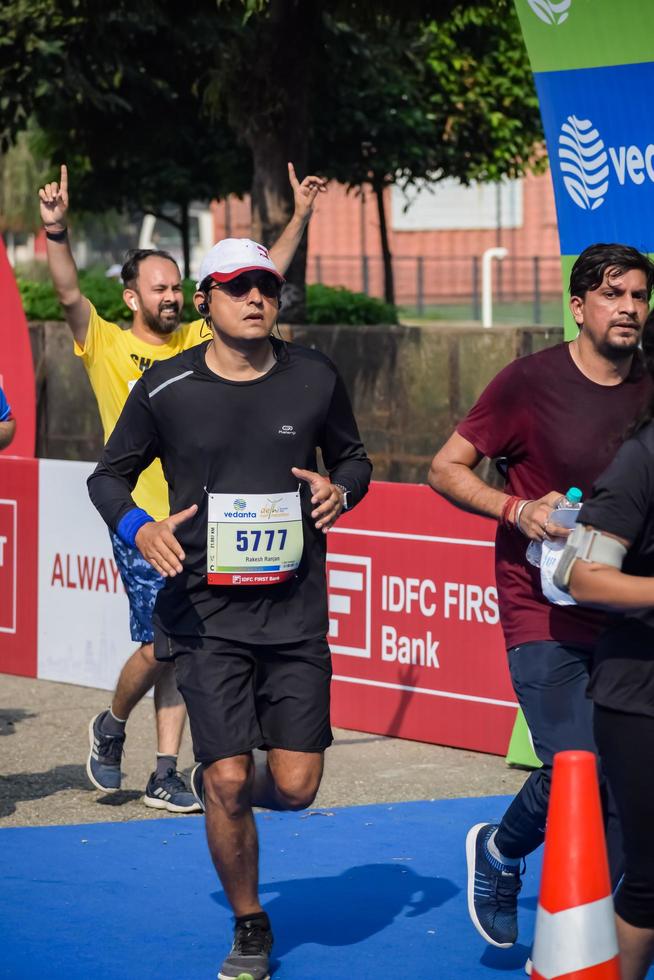 New Delhi, India - March 16 2023 - Vedanta Delhi Half Marathon race after covid in which marathon participants about to cross the finish line, Delhi Half Marathon 2022 photo