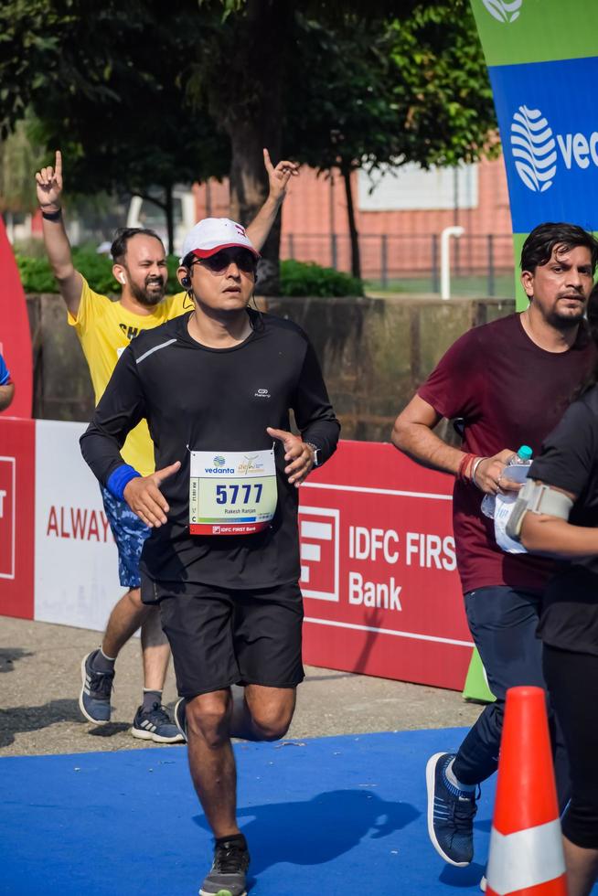 nuevo Delhi, India - marzo dieciséis 2023 - vedanta Delhi medio maratón carrera después codicioso en cuales maratón Participantes acerca de a cruzar el terminar línea, Delhi medio maratón 2022 foto