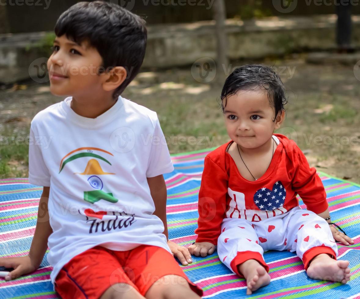 Two happy boys in society park, happy Asian brothers who are smiling happily together. Brothers play outdoors in summer, best friends. Toddler baby boy playing with his happy brother in the garden photo