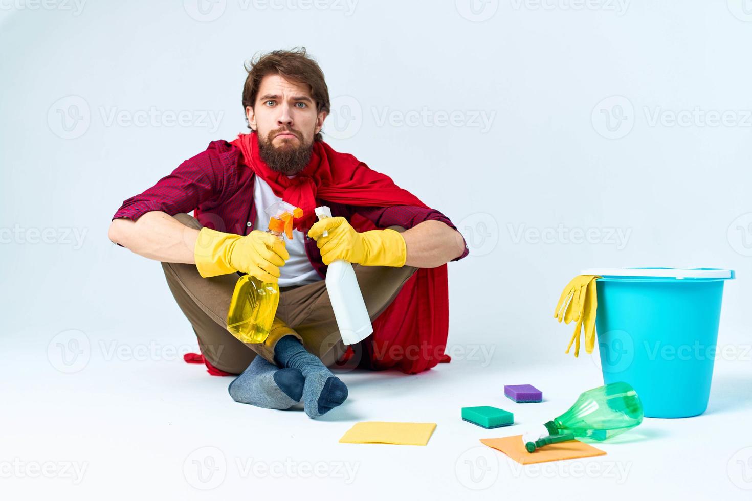 A man in a red raincoat sitting at home washing the floors providing services work photo