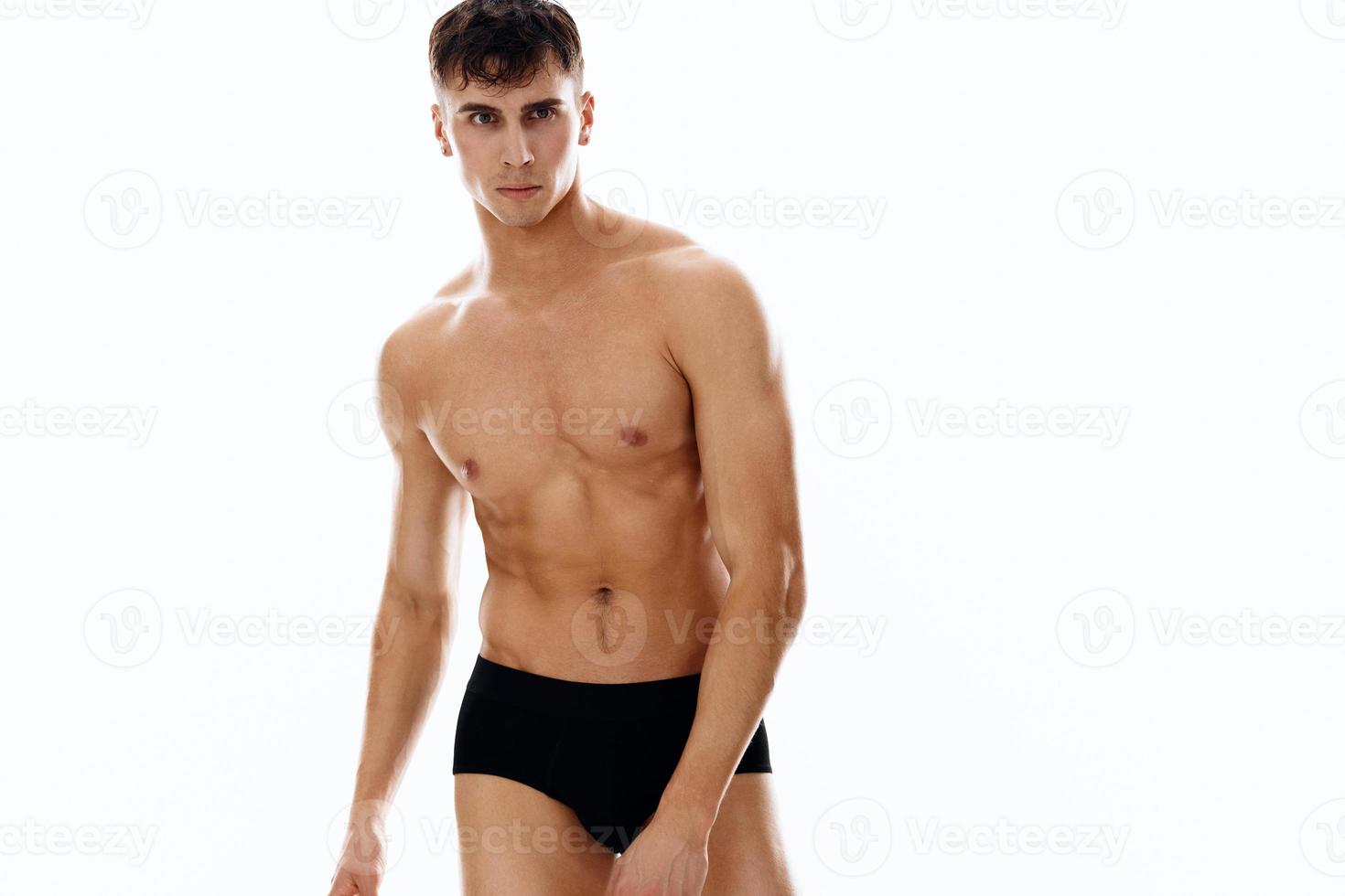 sporty man in dark shorts with a pumped body dark background photo