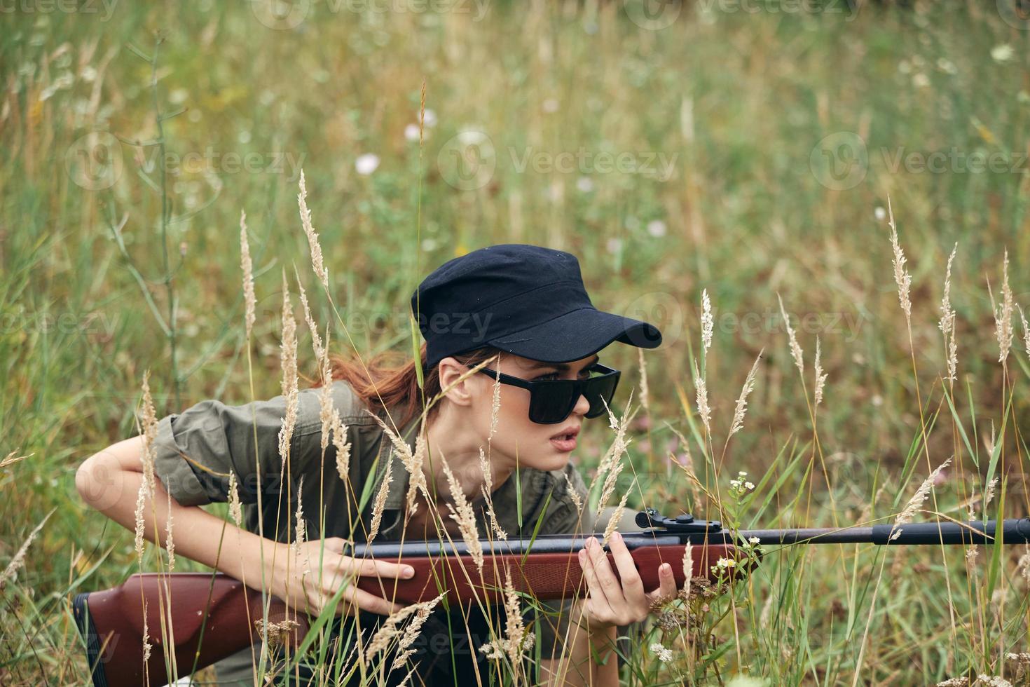 Woman soldier take cover on a gun hunt black cap photo