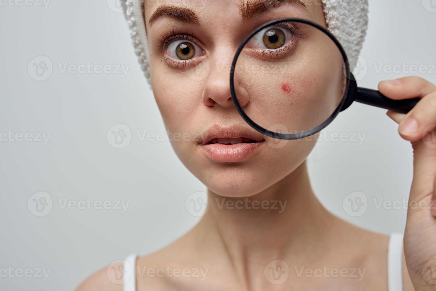 woman with a magnifying glass in hand cosmetology Studio photo