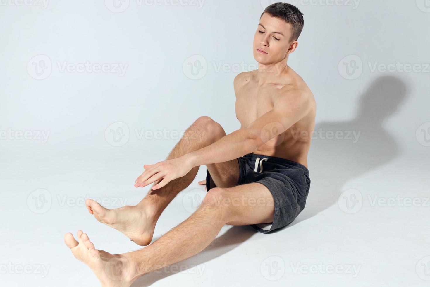 a guy doing morning exercises sitting on the floor indoors photo