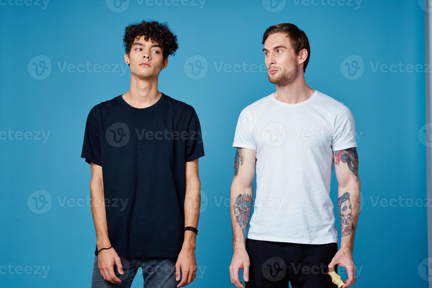 two men in t-shirts on a blue background and pants chatting friends photo