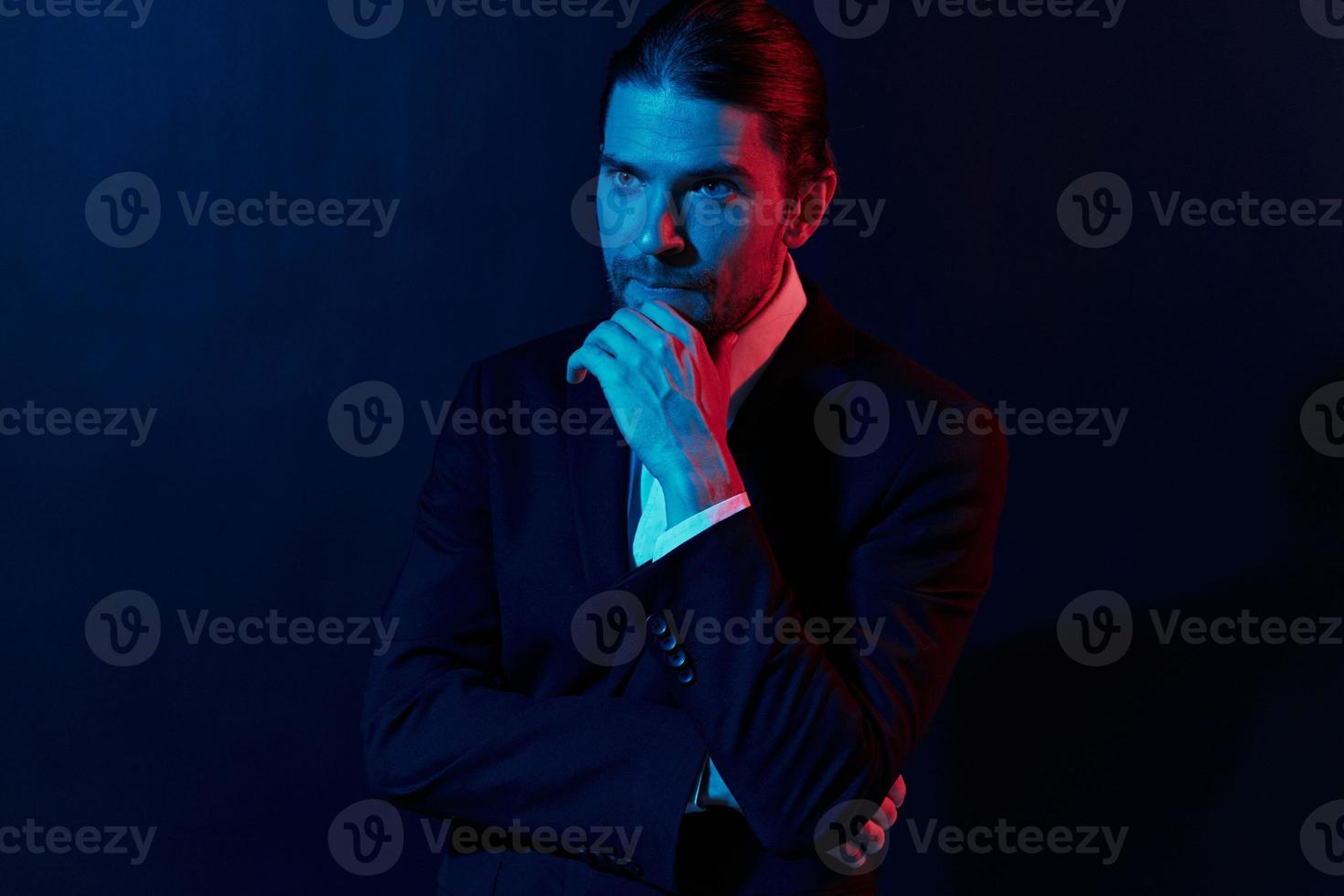 elegante hombre en un chaqueta posando yo confianza oscuro antecedentes foto