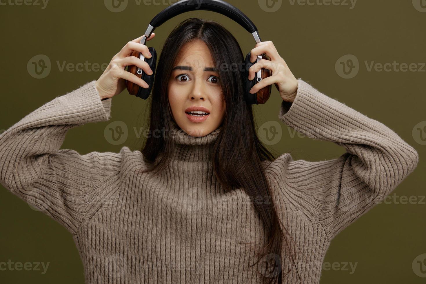 portrait woman in headphones listening to music emotions Green background photo