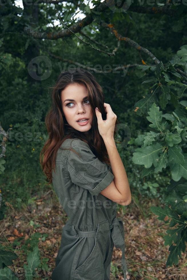 mujer en el bosque atractivo Mira en un verde traje Fresco aire antecedentes verano foto