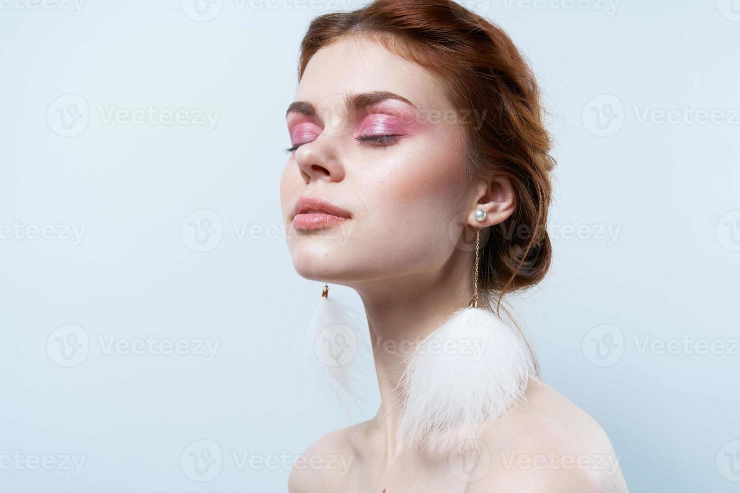 woman with bare shoulders and bright makeup jewelry fluffy earrings photo