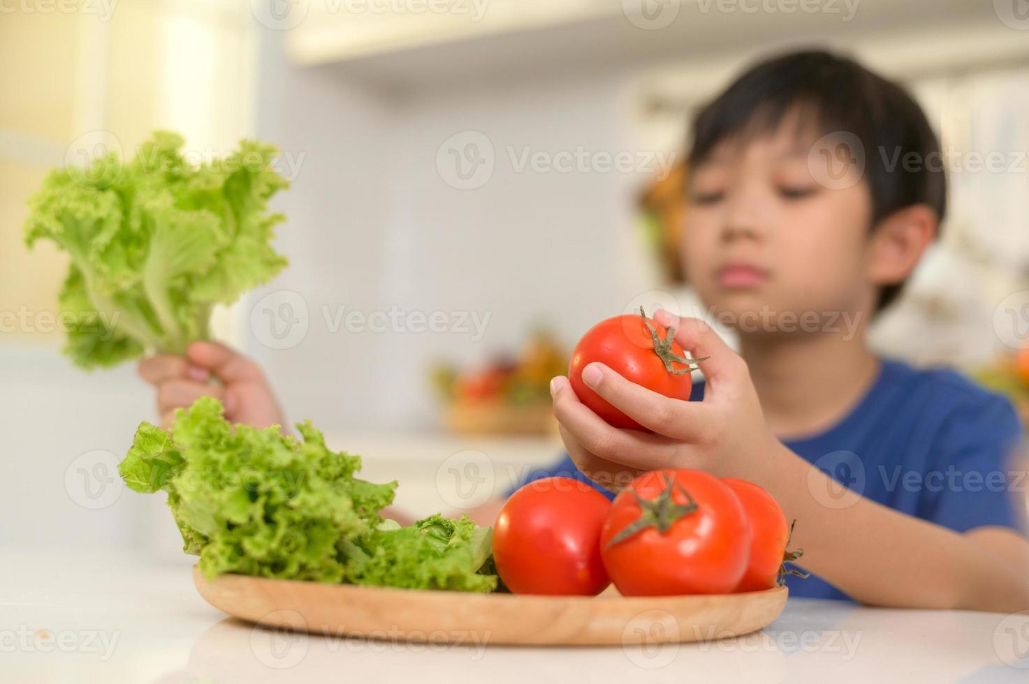 Asian boy feeling bored , unhappy to eat vegetables , health care concept photo