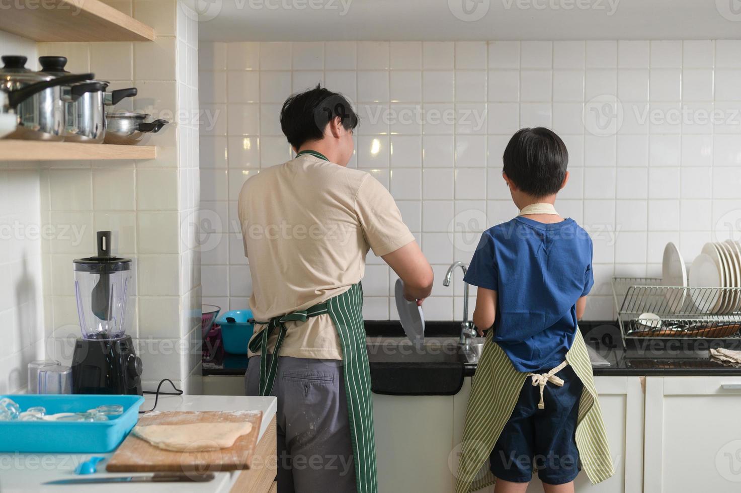 contento sonriente joven asiático padre y hijo Lavado platos en cocina a hogar foto