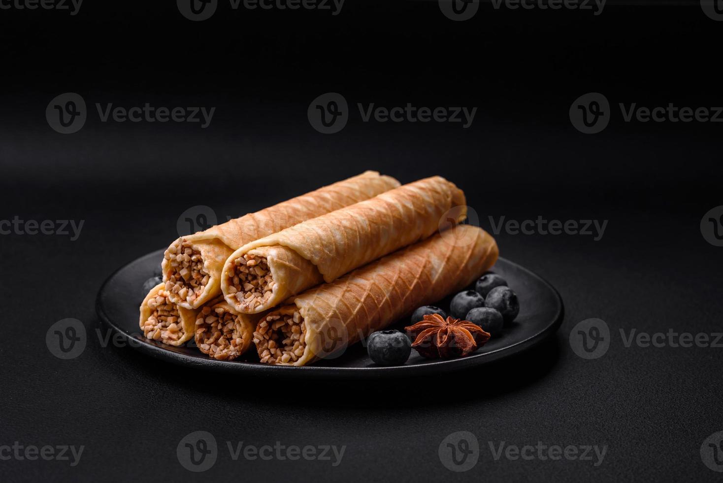 Delicious crispy wafer rolls with cream filling with nuts photo