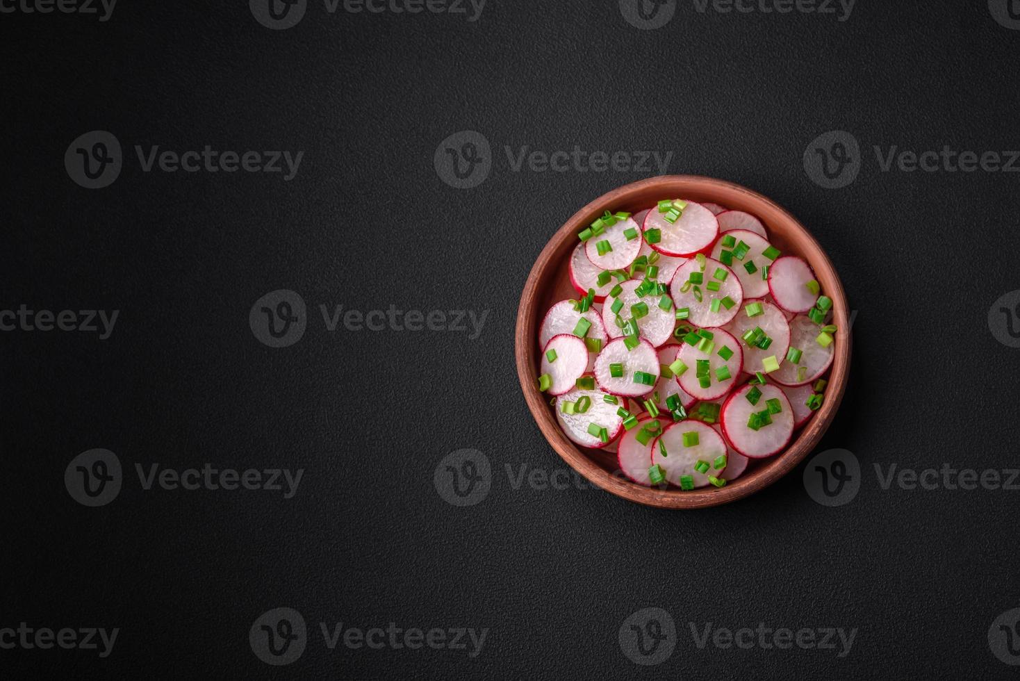 Delicious fresh salad of sliced radishes with green onions, salt and olive oil photo