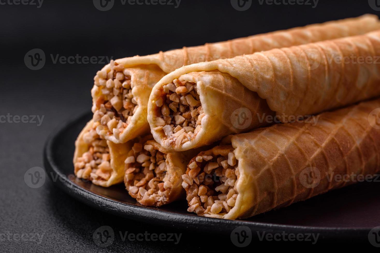 Delicious crispy wafer rolls with cream filling with nuts photo