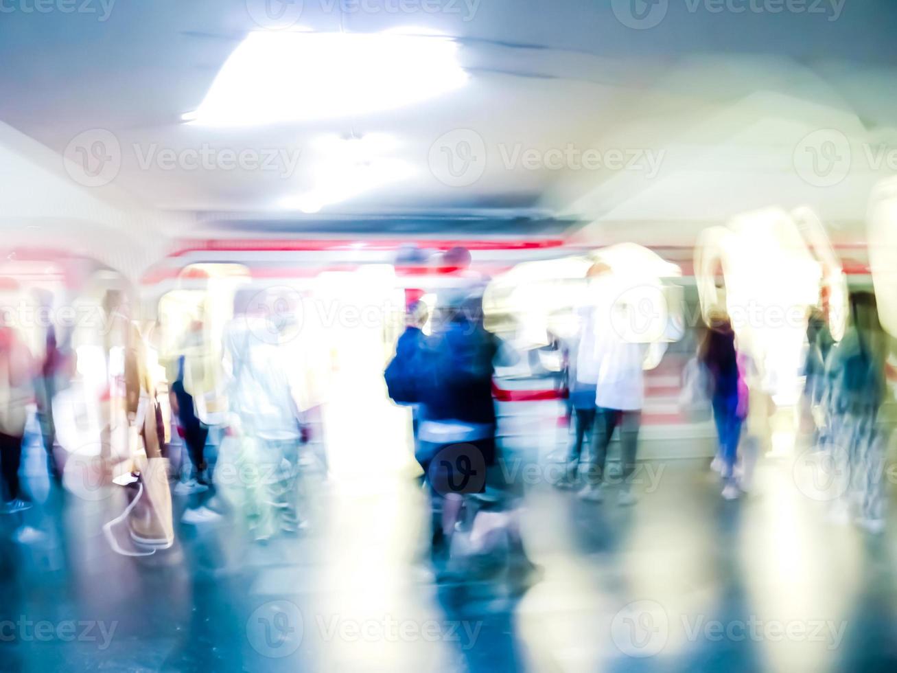 Lens blur image of a subway with moving human silhouettes and a train. Motion blur image of people. photo