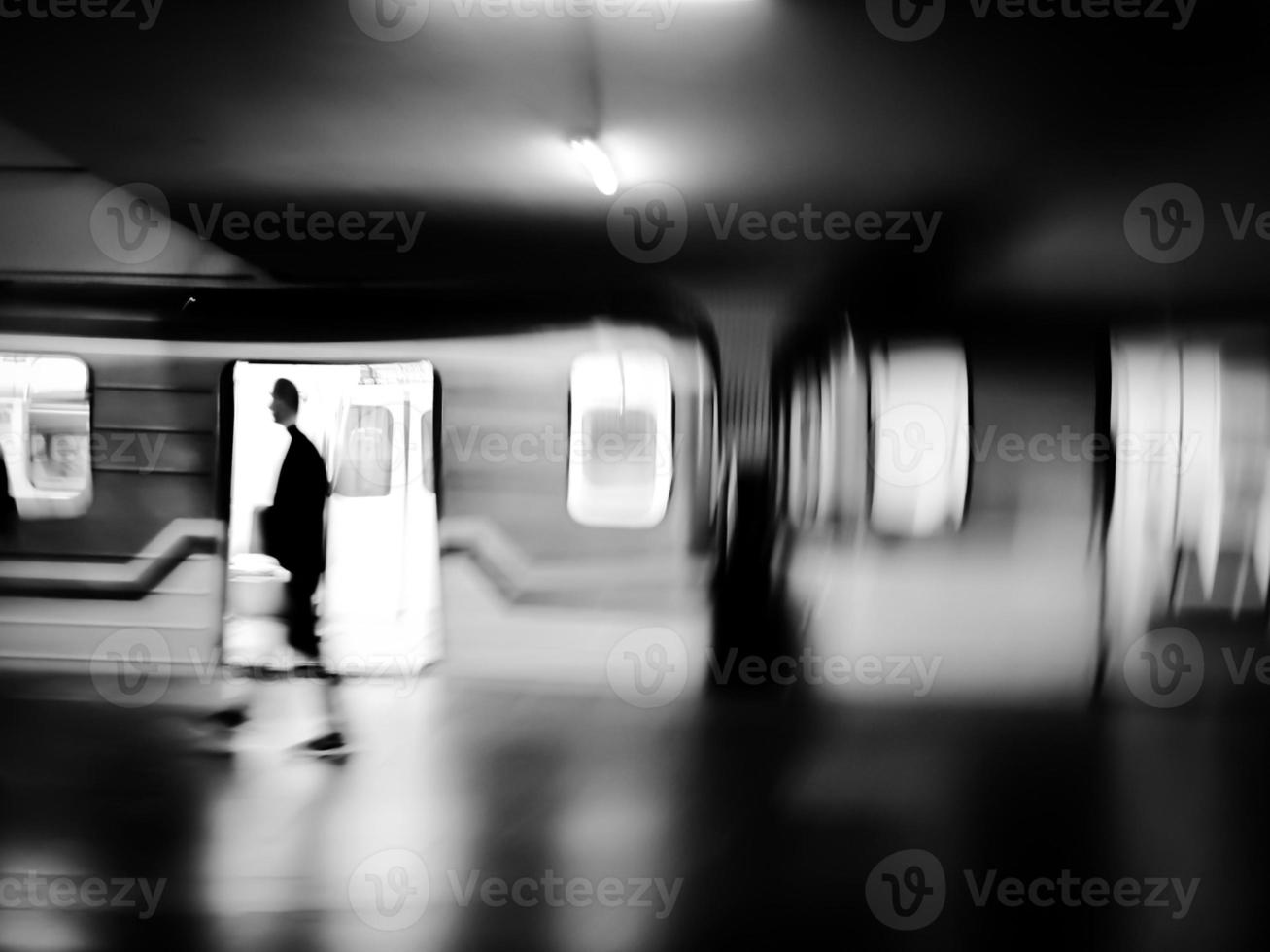 Black and white motion blur image of subway with a train and passengers. photo