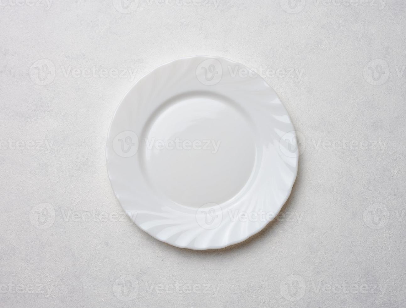 Empty white plate on white background, top view photo