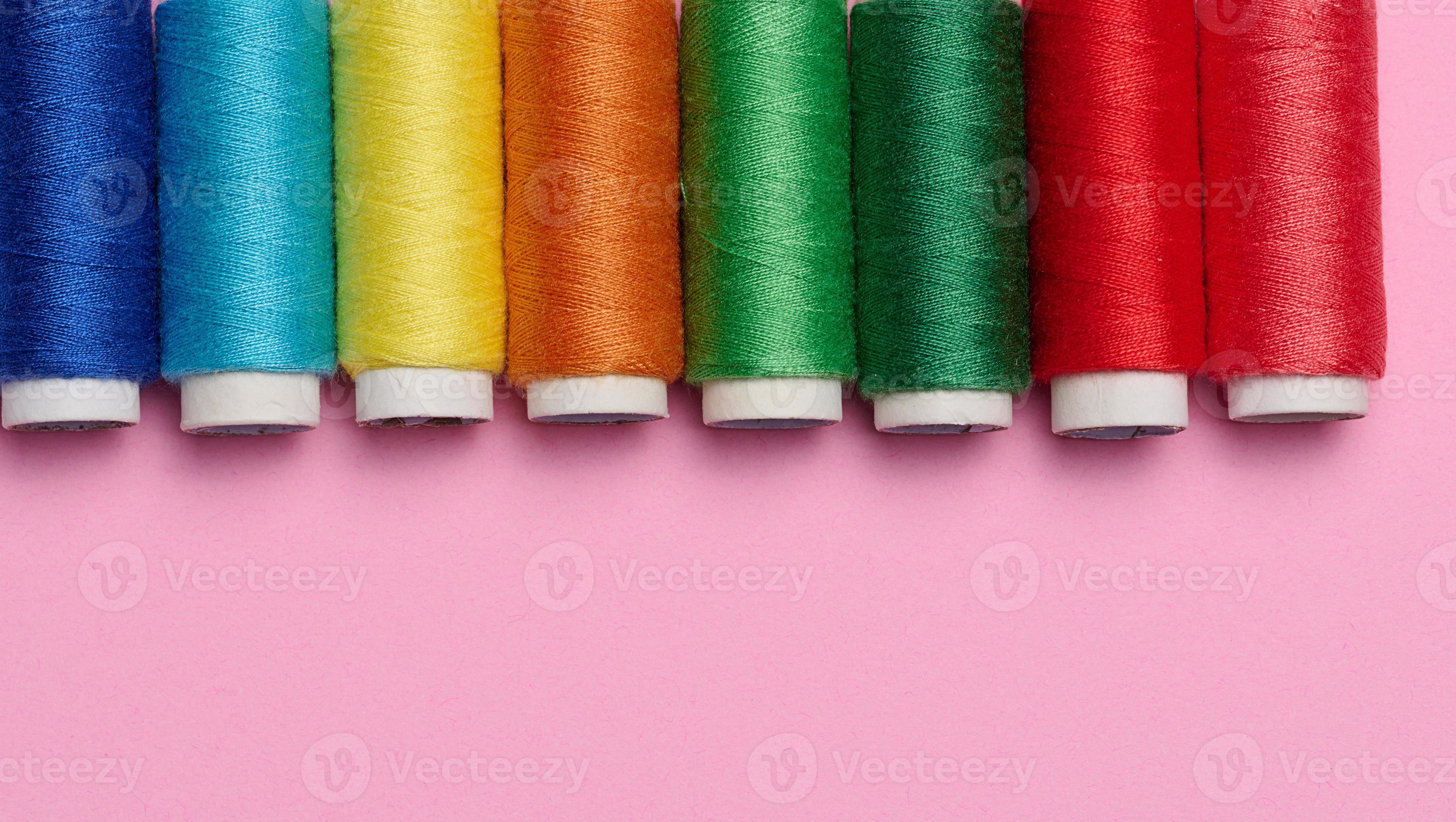 Multicolored spools of sewing threads on a pink background, top view  22336711 Stock Photo at Vecteezy