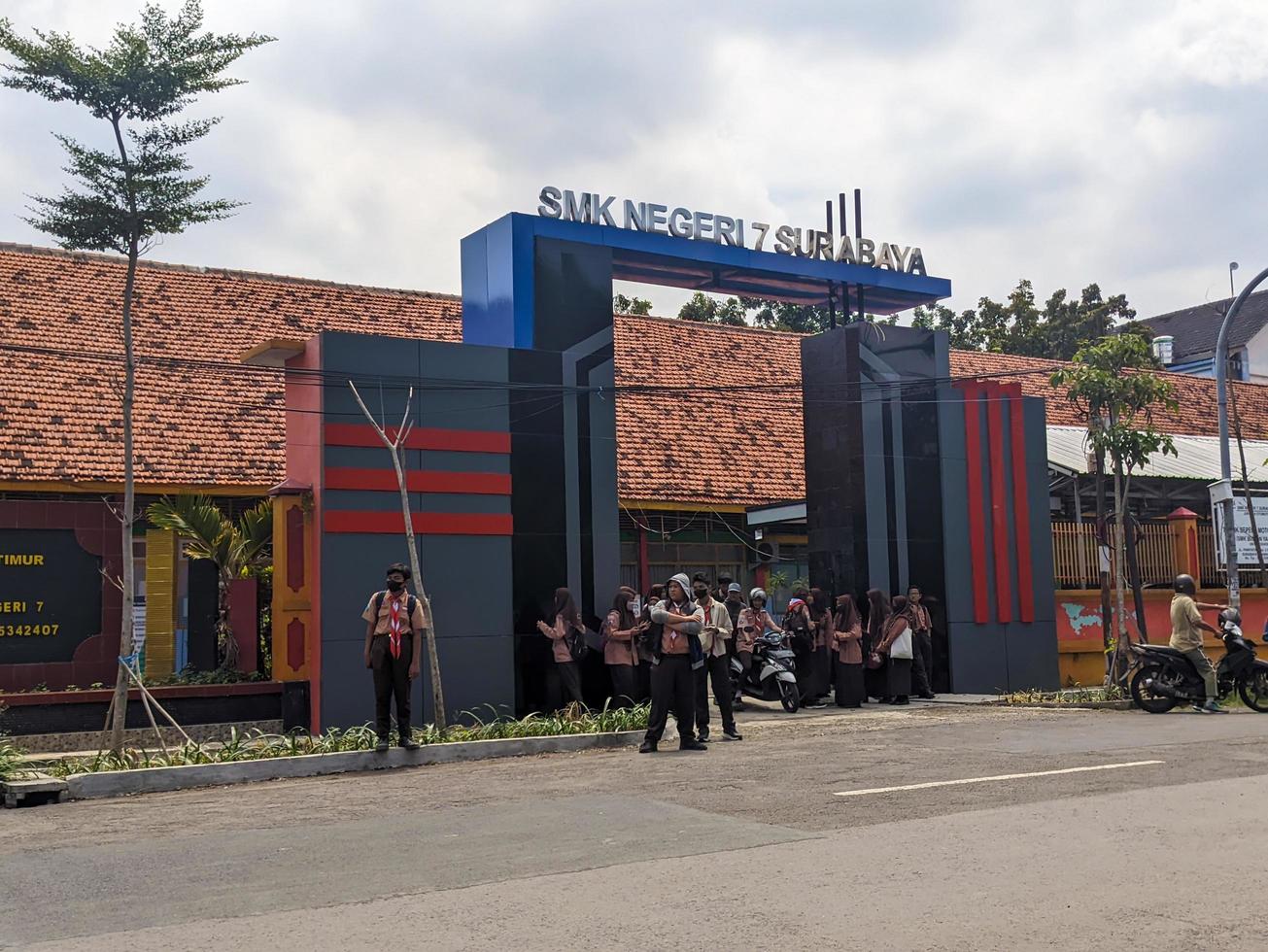 view of the front area of the school with many students coming home from school photo