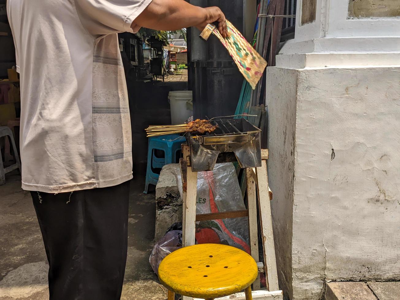 a satay seller roasting satay or sate over a fire photo